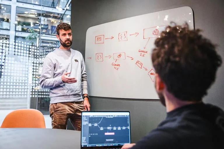 Underviser forklarer en arbejdsgang med AI ved et whiteboard