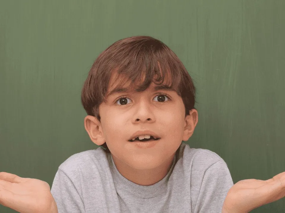 Dreng på 7 år står med åbne håndflader, indikerer han ikke forstår hvad der menes.